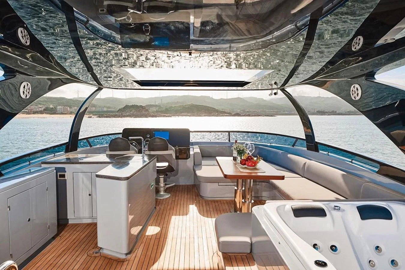 The flybridge offers a luxurious space with a hot tub, dining area, and helm station, all under a sleek canopy with panoramic views. aboard 7809 Yacht for Sale