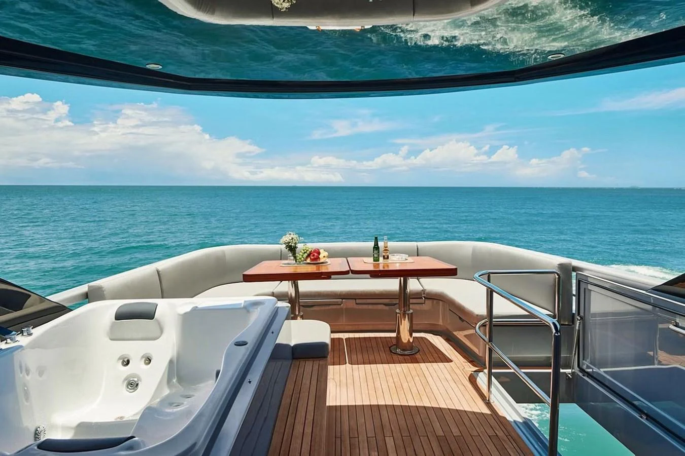 The aft deck features a luxurious jacuzzi and a dining area with stunning ocean views. aboard 7809 Yacht for Sale