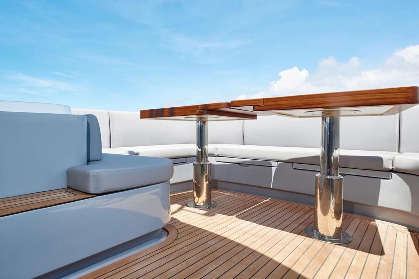 The aft deck features a stylish seating area with a polished wooden table and comfortable cushions, perfect for outdoor relaxation. aboard 7809 Yacht for Sale