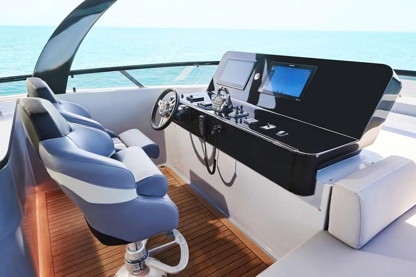 The helm station features modern navigation equipment and comfortable seating with a stunning ocean view. aboard 7809 Yacht for Sale