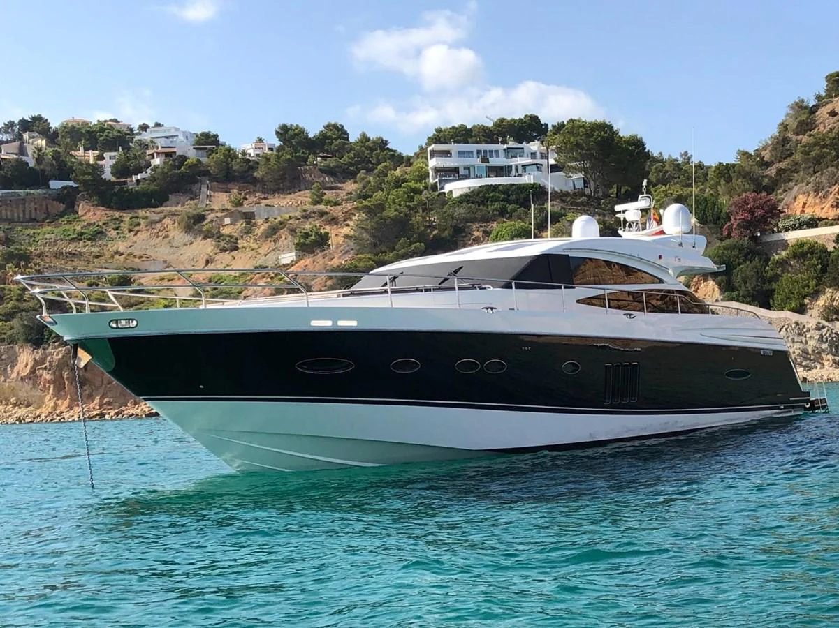 A sleek and modern yacht glides gracefully on clear blue waters near a scenic coastline. aboard SFYFALL Yacht for Sale