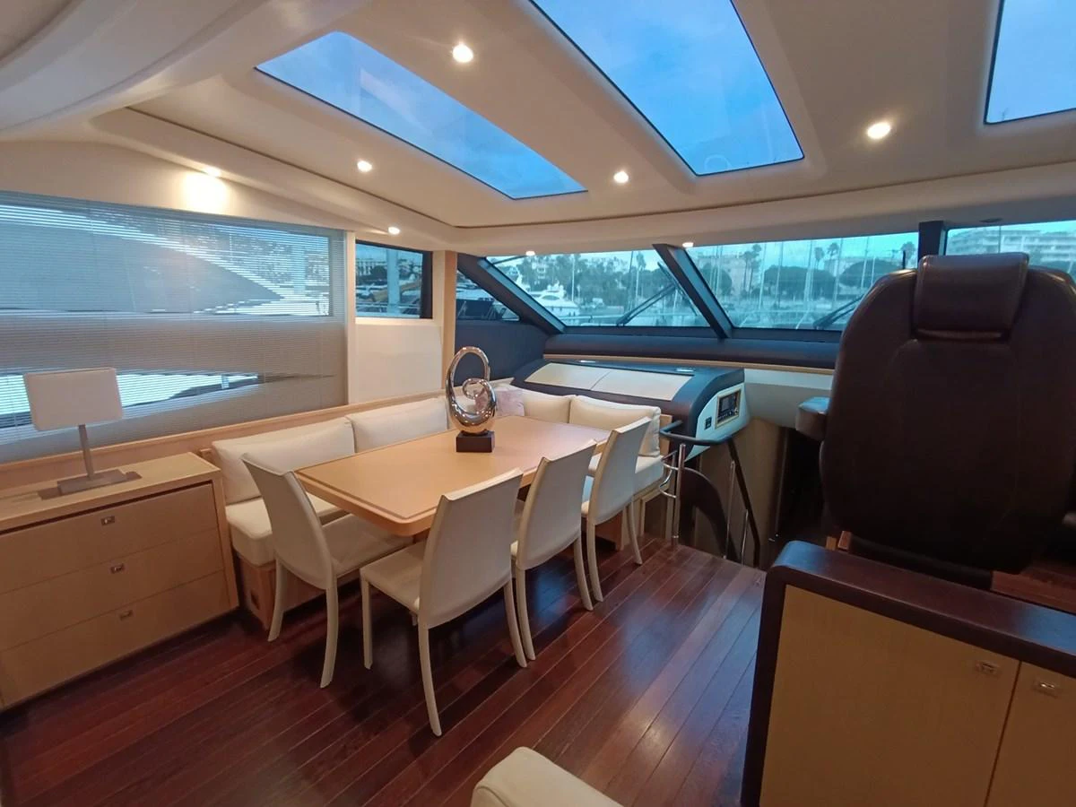 The yacht's dining area features a spacious table with comfortable seating and large windows for natural light. aboard SFYFALL Yacht for Sale