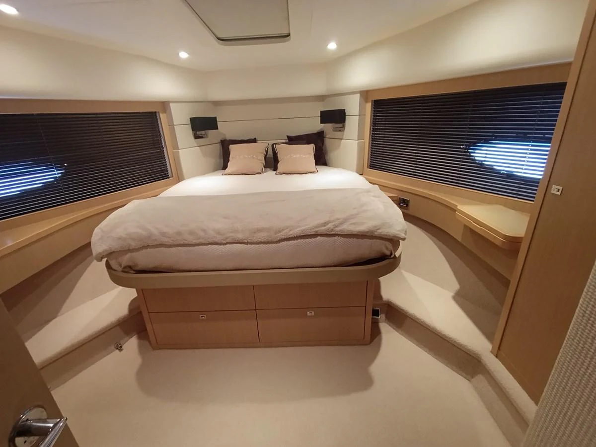 The master stateroom features a spacious bed with elegant wood finishes and ample natural light. aboard SFYFALL Yacht for Sale