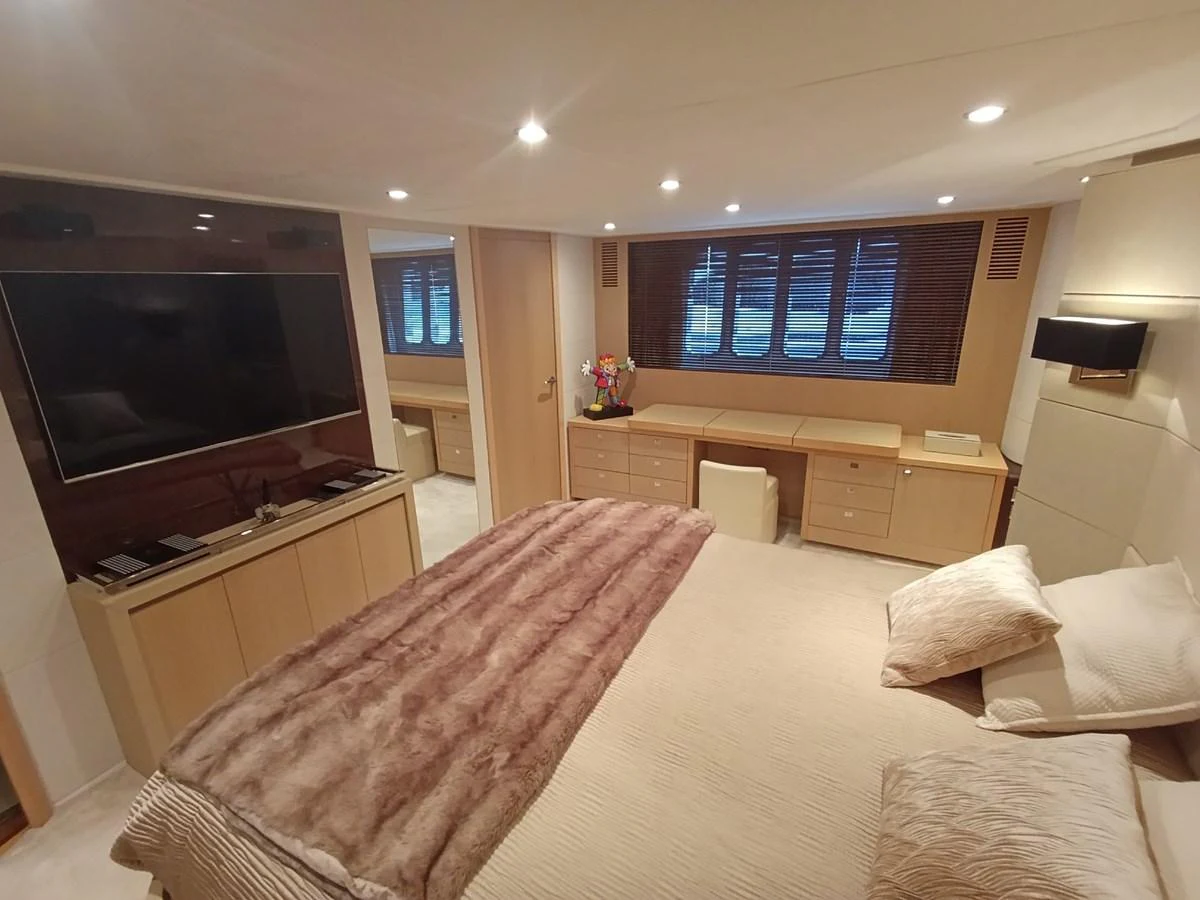 The master stateroom features a luxurious bed, ample storage, and a large television. aboard SFYFALL Yacht for Sale