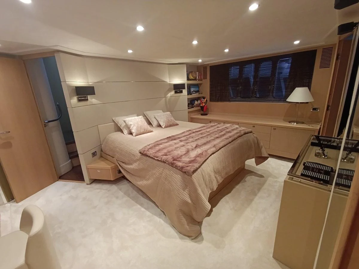The master stateroom features a luxurious bed with plush bedding and modern lighting. aboard SFYFALL Yacht for Sale