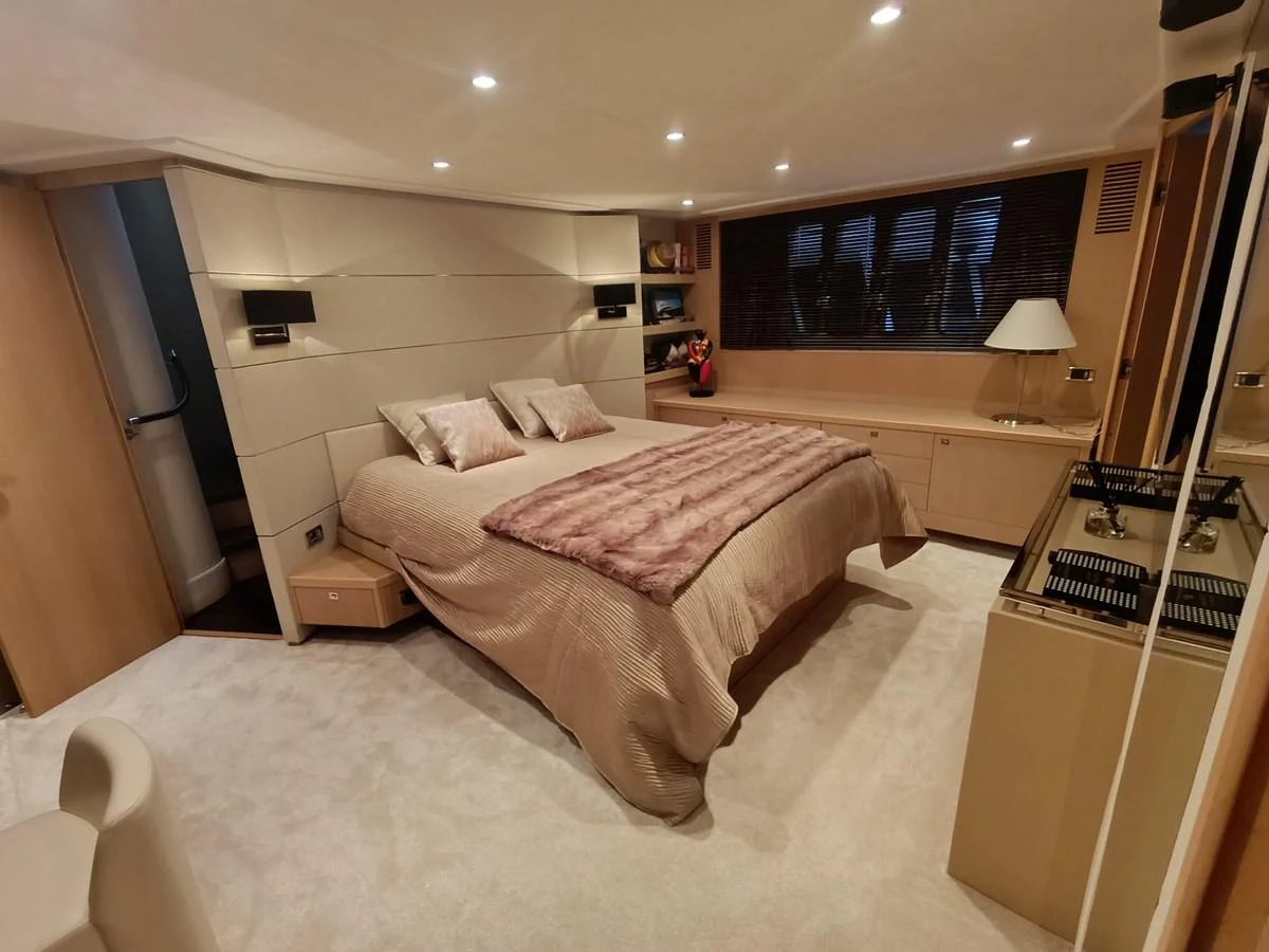 The master stateroom features a luxurious bed with plush bedding and elegant lighting. aboard SFYFALL Yacht for Sale