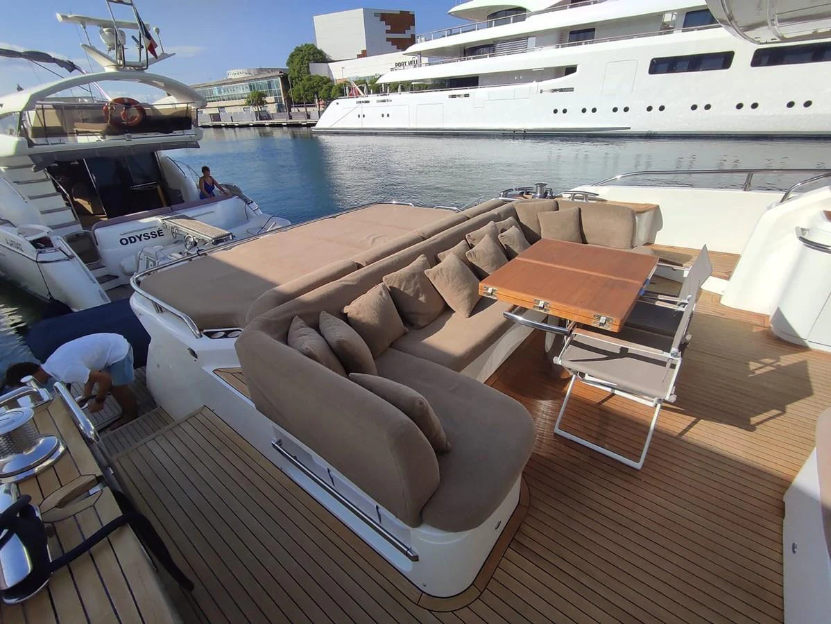The aft deck features a spacious lounging area with plush seating and a dining table, perfect for outdoor relaxation and dining. aboard SFYFALL Yacht for Sale