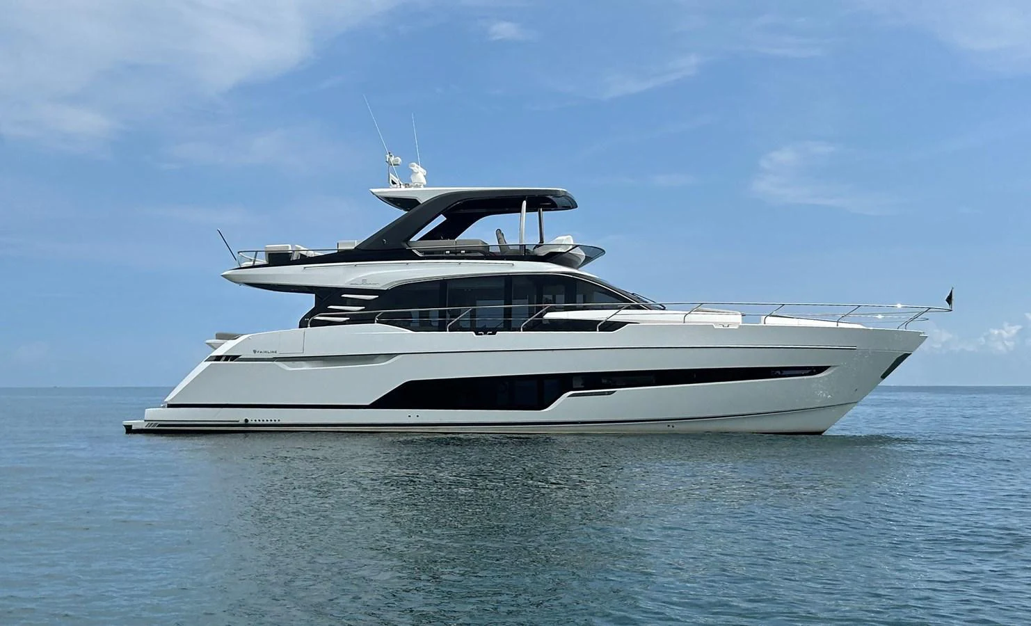 A sleek and modern yacht glides gracefully on calm waters under a clear blue sky. aboard FAIRLINE SQUADRON Yacht for Sale
