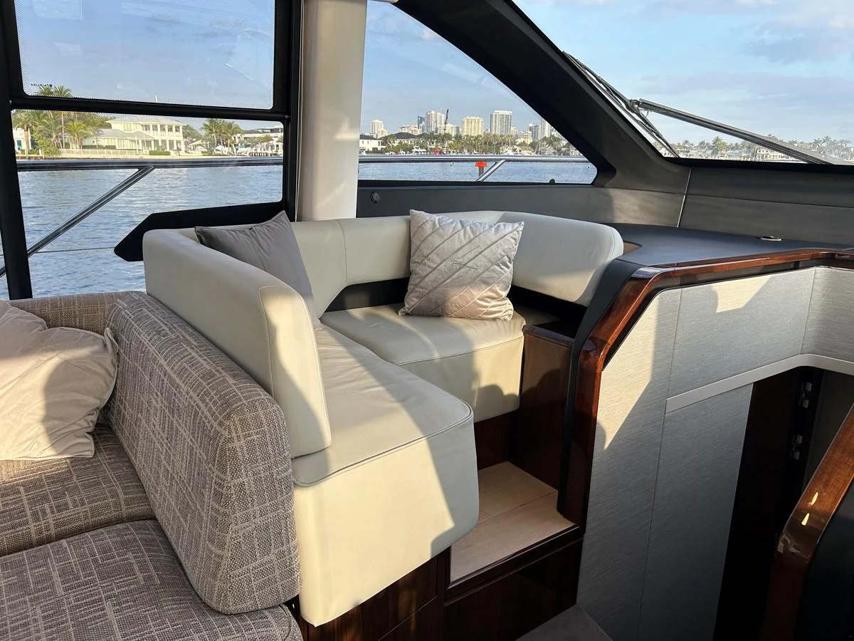 The yacht's salon features comfortable seating with a scenic view through large windows. aboard FAIRLINE SQUADRON Yacht for Sale