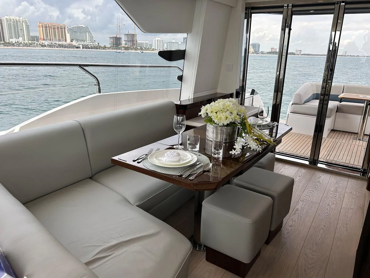 The yacht's dining area offers a sophisticated setting with a view of the water through large windows. aboard FAIRLINE SQUADRON Yacht for Sale