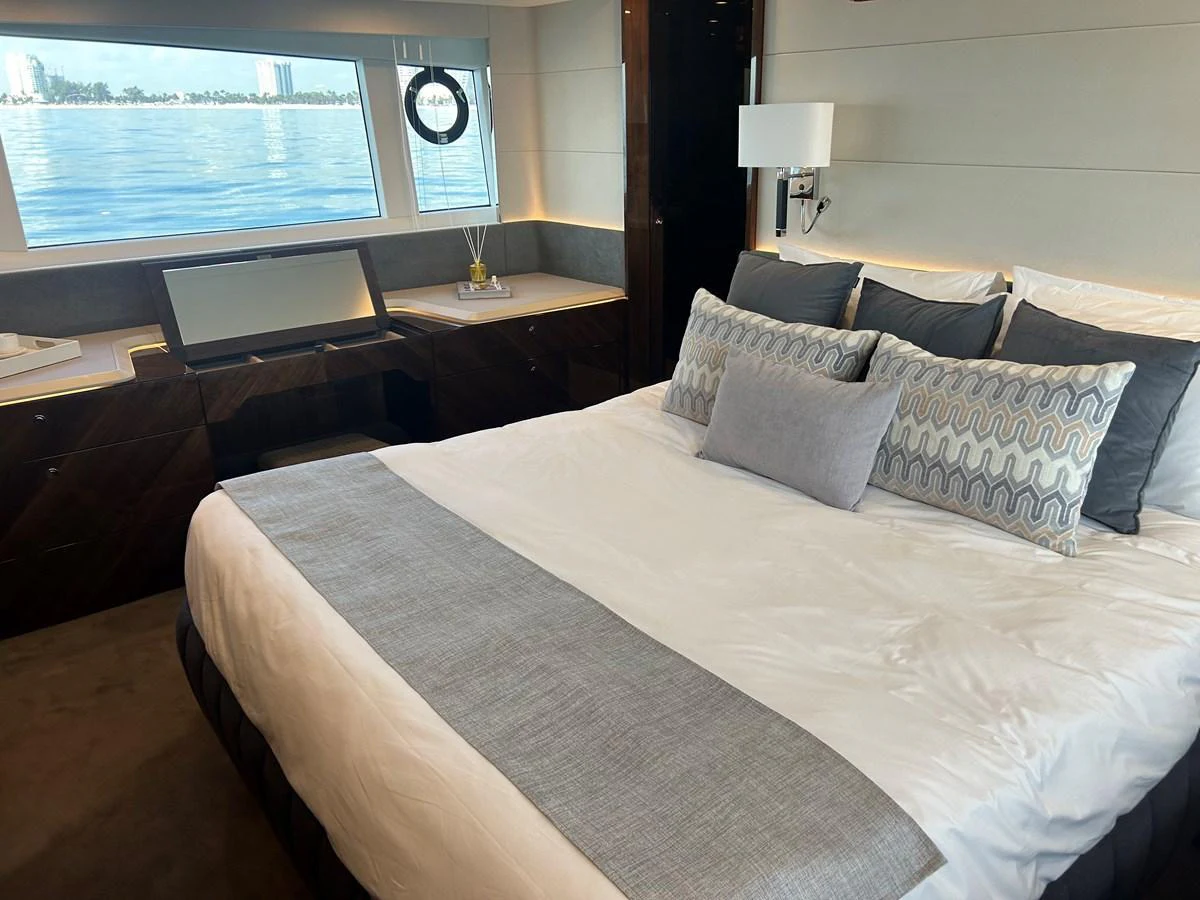 A luxurious stateroom featuring a large bed with elegant bedding and a scenic view through the windows. aboard FAIRLINE SQUADRON Yacht for Sale