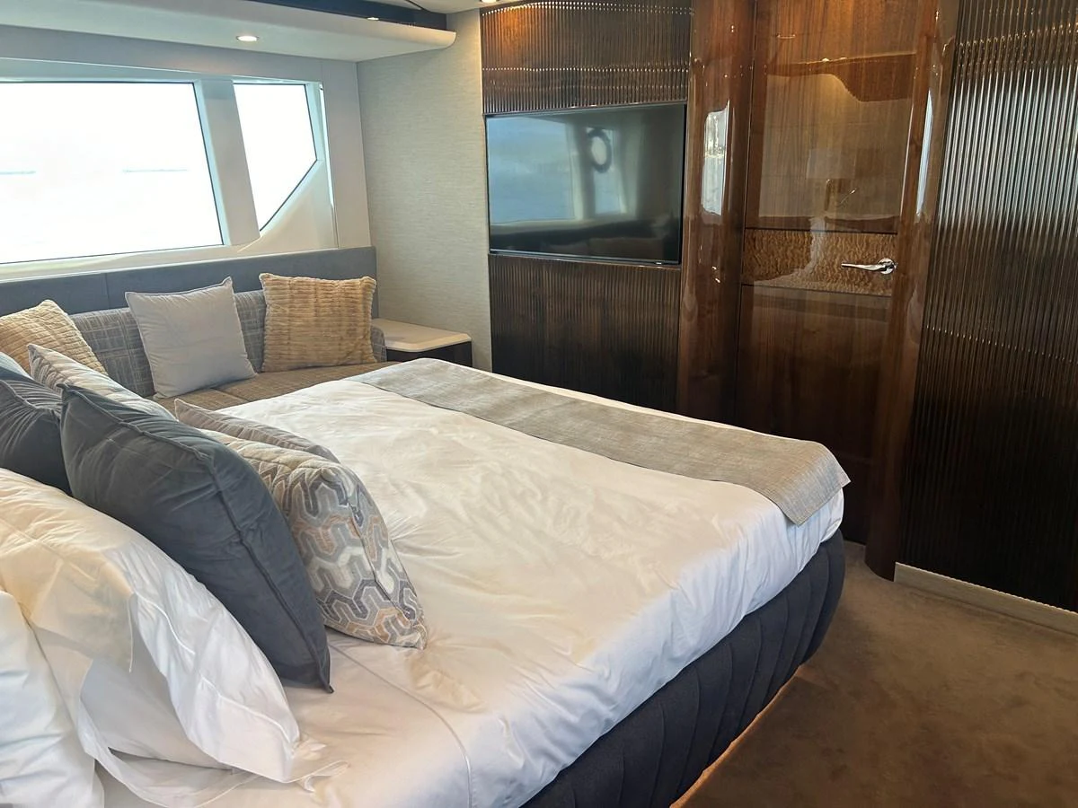 The stateroom features a plush bed with elegant bedding and a modern entertainment system. aboard FAIRLINE SQUADRON Yacht for Sale