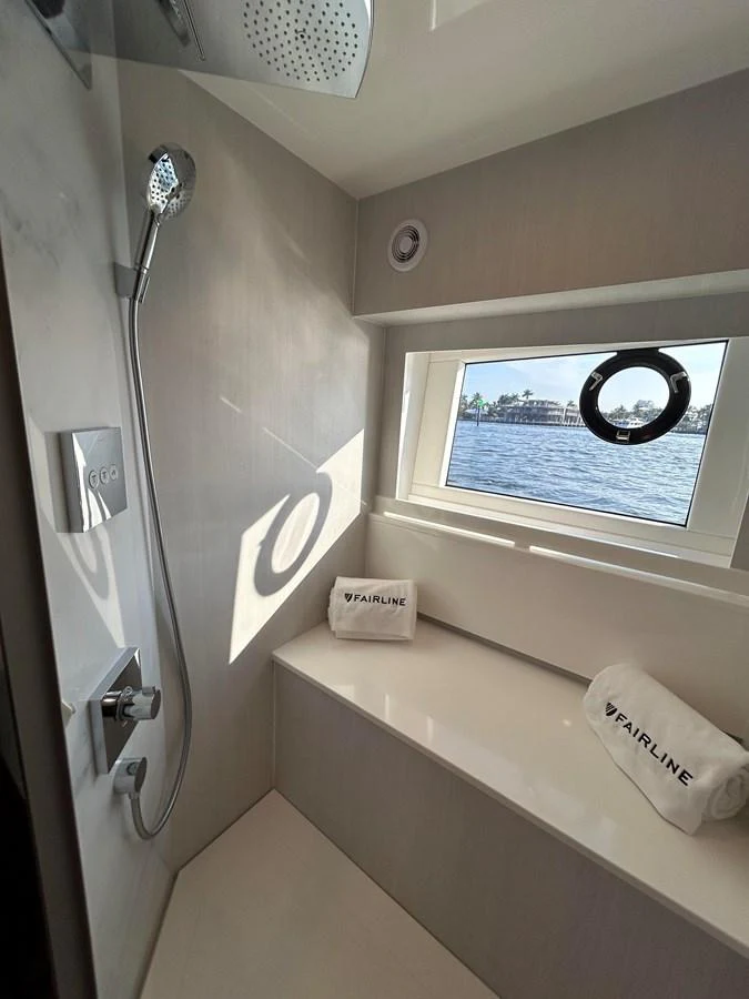 A sleek and modern yacht bathroom with a window offering a view of the water. aboard FAIRLINE SQUADRON Yacht for Sale