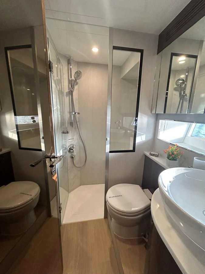 The yacht's bathroom features a modern shower, toilet, and sink with sleek finishes. aboard FAIRLINE SQUADRON Yacht for Sale