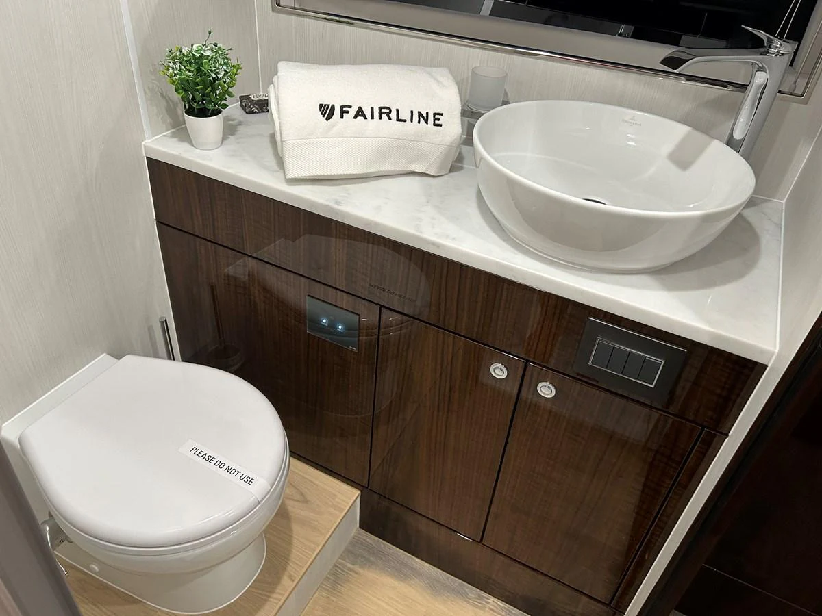 A modern yacht bathroom featuring a sleek sink and a compact toilet. aboard FAIRLINE SQUADRON Yacht for Sale