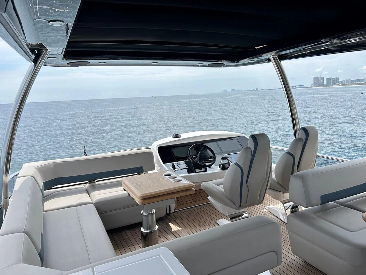 The helm area features comfortable seating and a sleek control station with a panoramic ocean view. aboard FAIRLINE SQUADRON Yacht for Sale