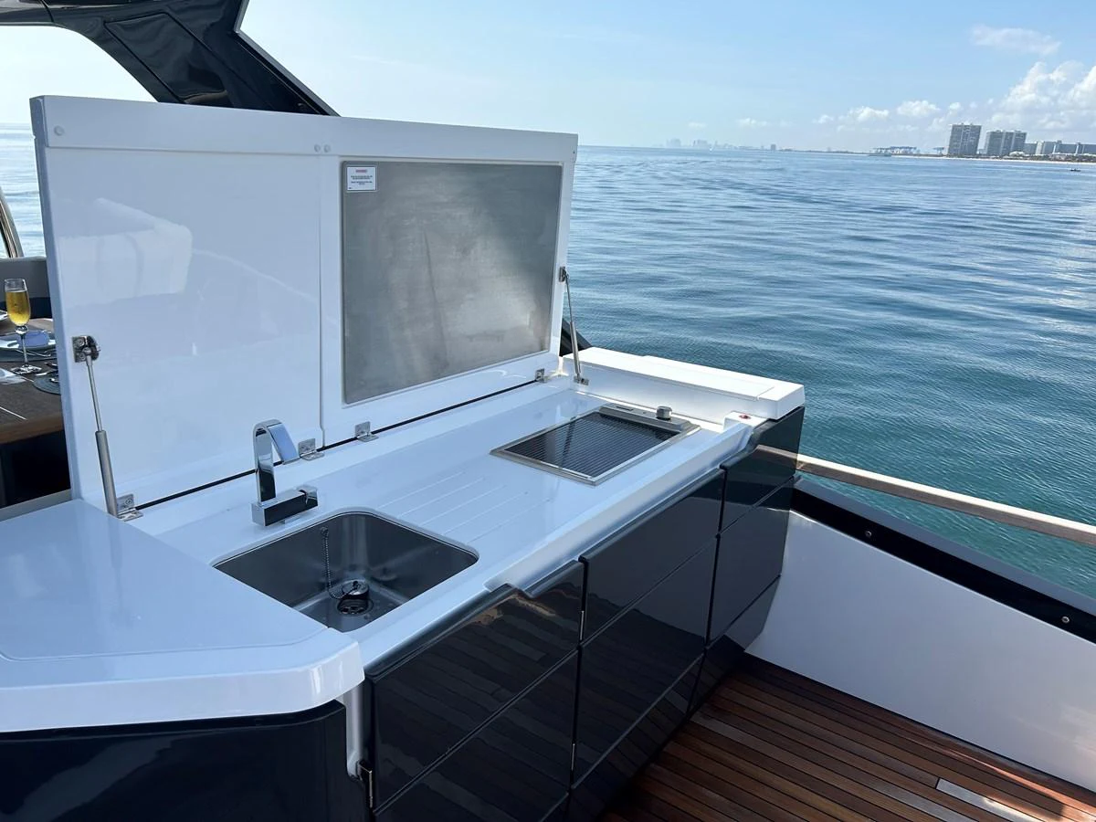 The yacht features a sleek outdoor galley with modern amenities and a stunning ocean view. aboard FAIRLINE SQUADRON Yacht for Sale
