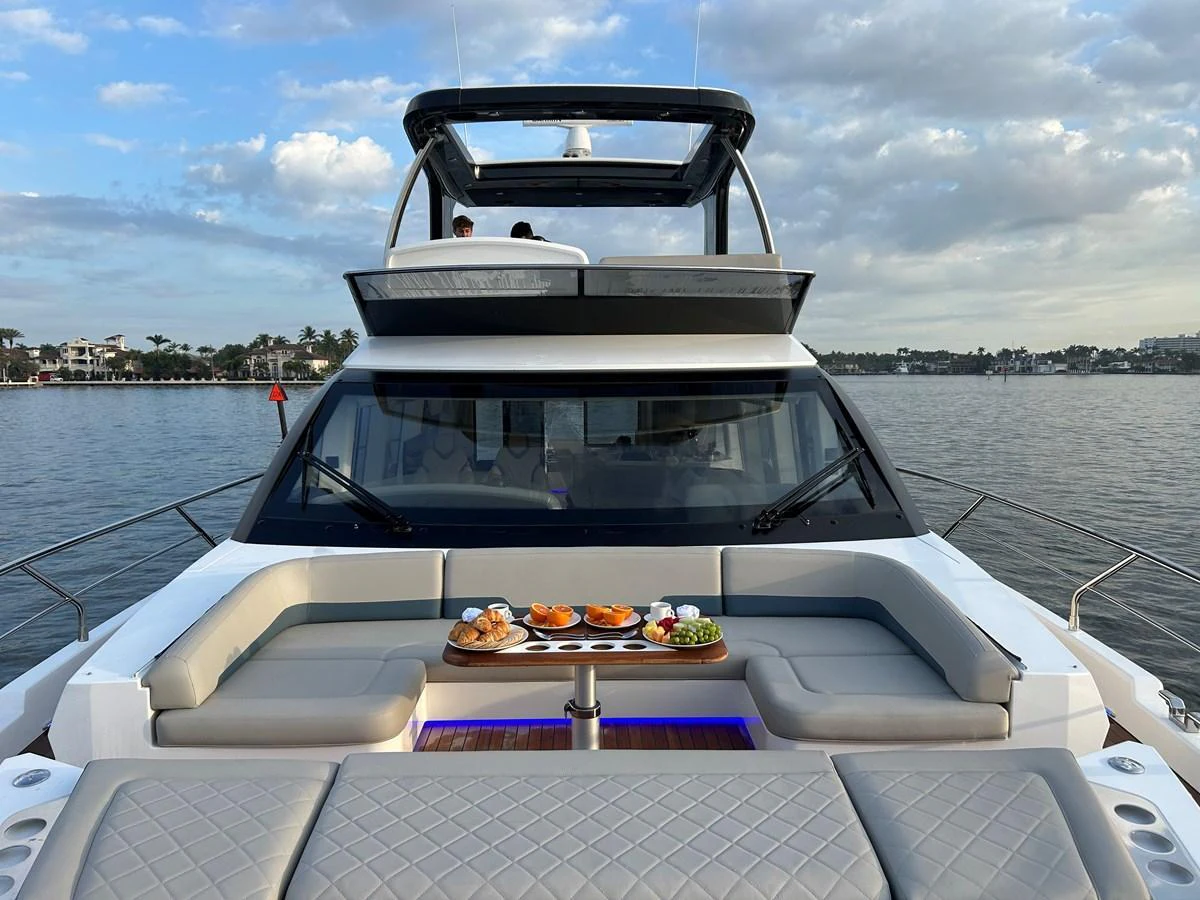 The yacht's bow area features a luxurious seating arrangement with a table set for dining, offering a perfect spot to enjoy the view. aboard FAIRLINE SQUADRON Yacht for Sale