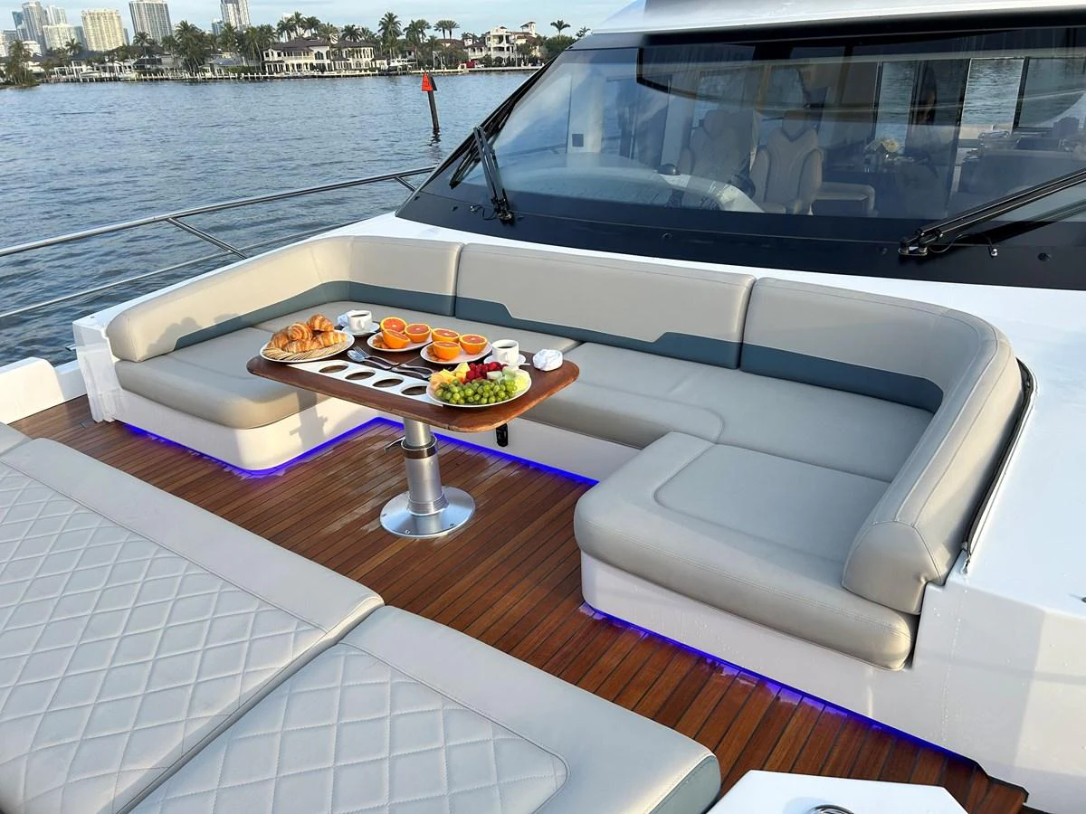 The aft deck features a comfortable seating area with a table set for refreshments, perfect for enjoying the view. aboard FAIRLINE SQUADRON Yacht for Sale