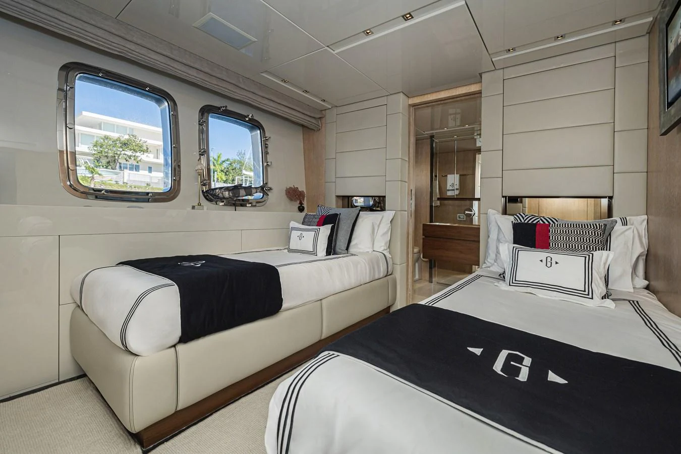 The guest stateroom features twin beds with elegant bedding and a view through large windows. aboard PERCAL Yacht for Sale