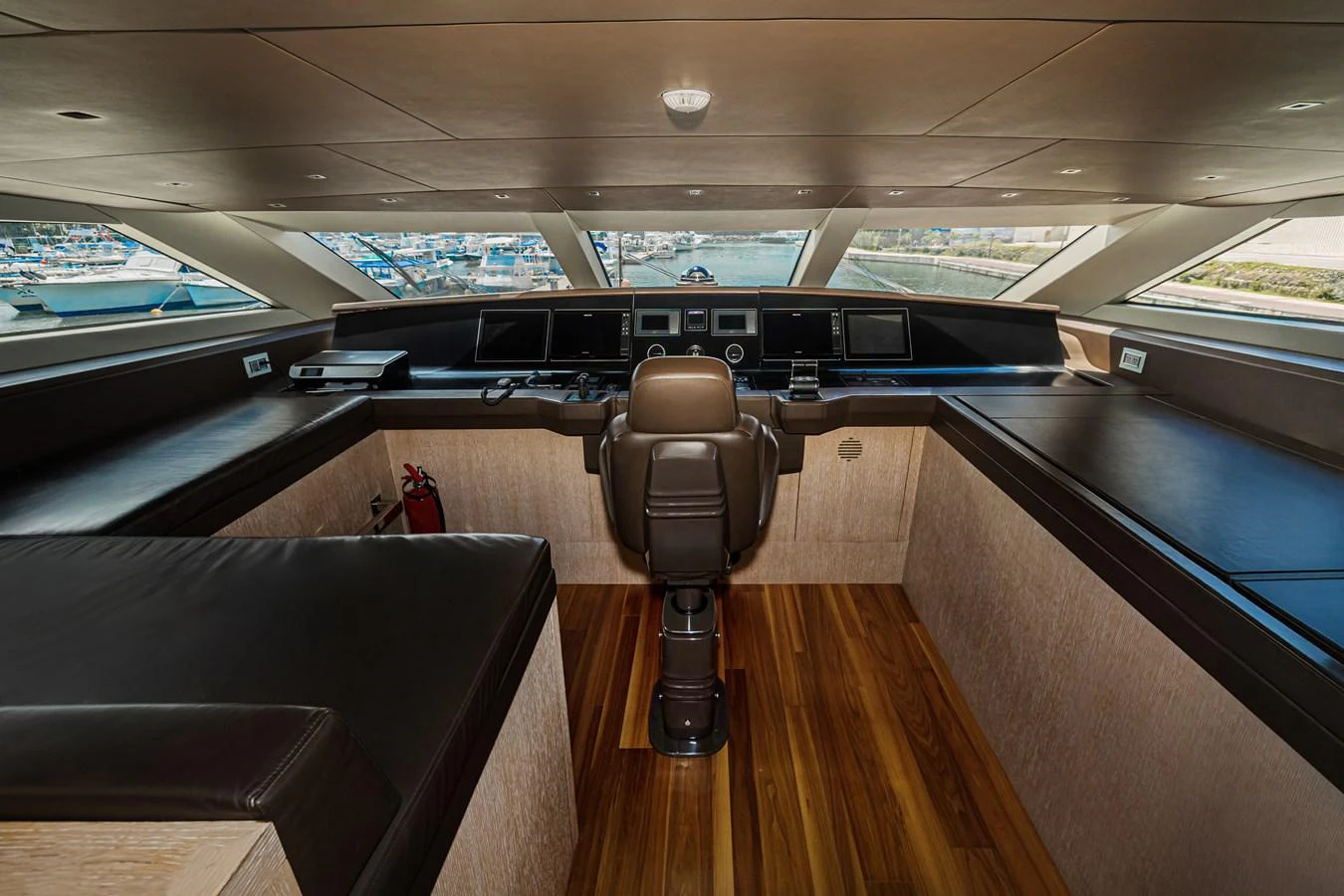 The helm station features a sleek design with modern navigation equipment and a comfortable captain's chair. aboard PERCAL Yacht for Sale