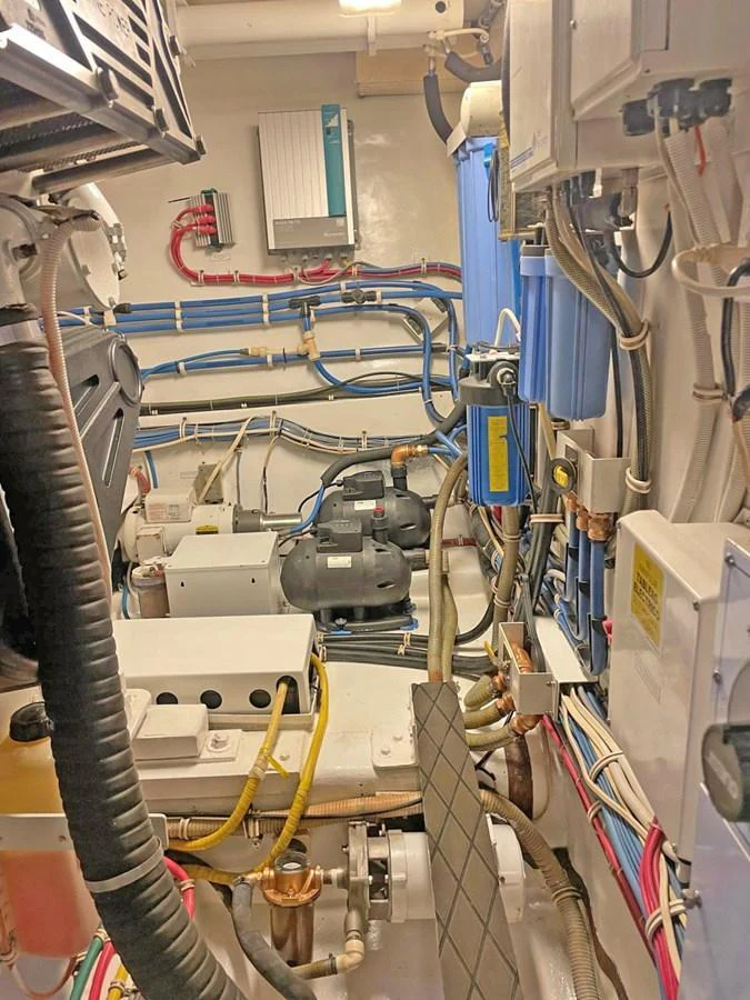 The image shows a well-organized engine room with various mechanical and electrical components. aboard HATTERAS 68 CONVERTIBLE Yacht for Sale