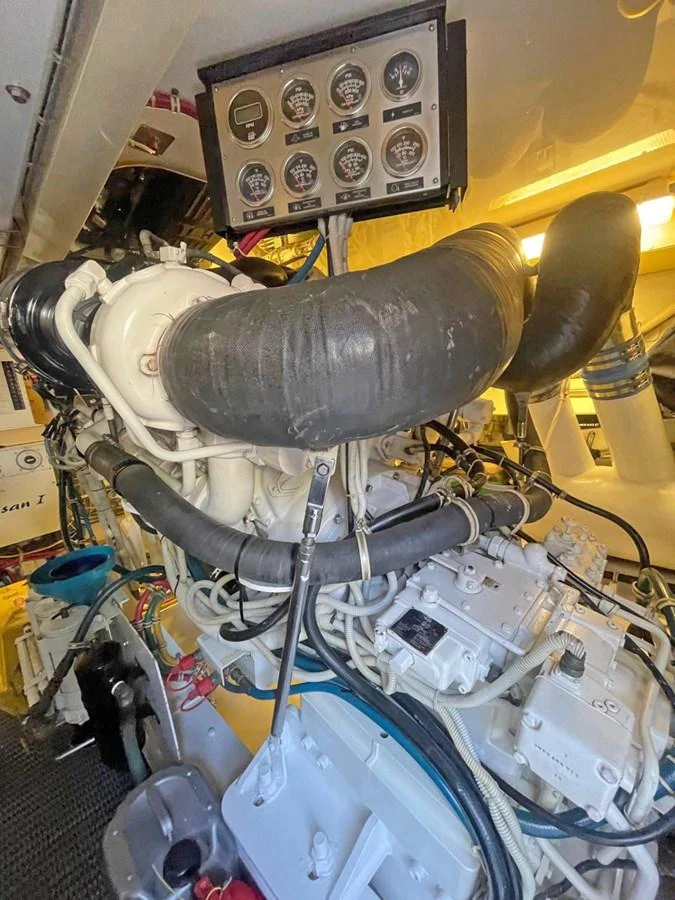 The image showcases the yacht's engine room with detailed machinery and control panels. aboard HATTERAS 68 CONVERTIBLE Yacht for Sale