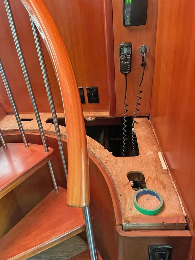 A wooden spiral staircase with a built-in communication device and control panel. aboard HATTERAS 68 CONVERTIBLE Yacht for Sale