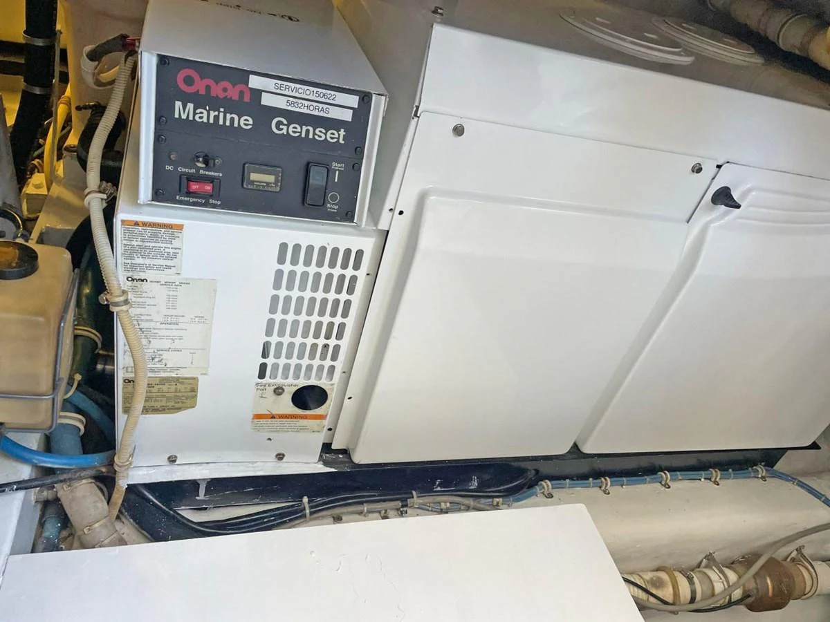 The image showcases the yacht's engine room with an Onan Marine Genset generator. aboard HATTERAS 68 CONVERTIBLE Yacht for Sale