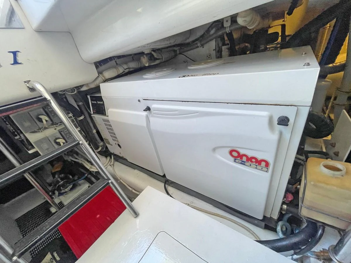 The image shows a detailed view of the yacht's engine room, featuring an Onan generator. aboard HATTERAS 68 CONVERTIBLE Yacht for Sale