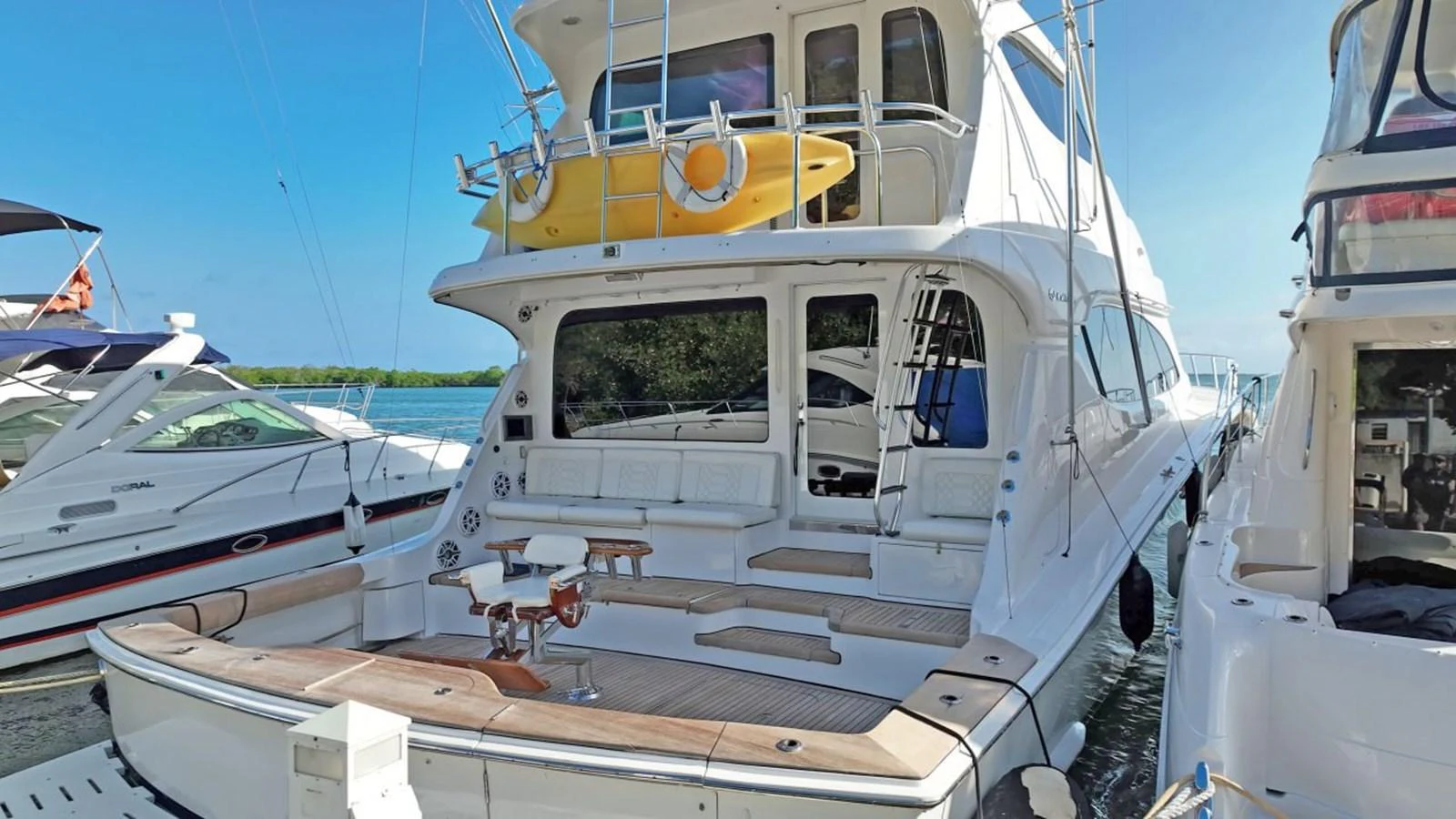 The yacht's aft deck features comfortable seating and a well-equipped area for relaxation and socializing. aboard HATTERAS 68 CONVERTIBLE Yacht for Sale