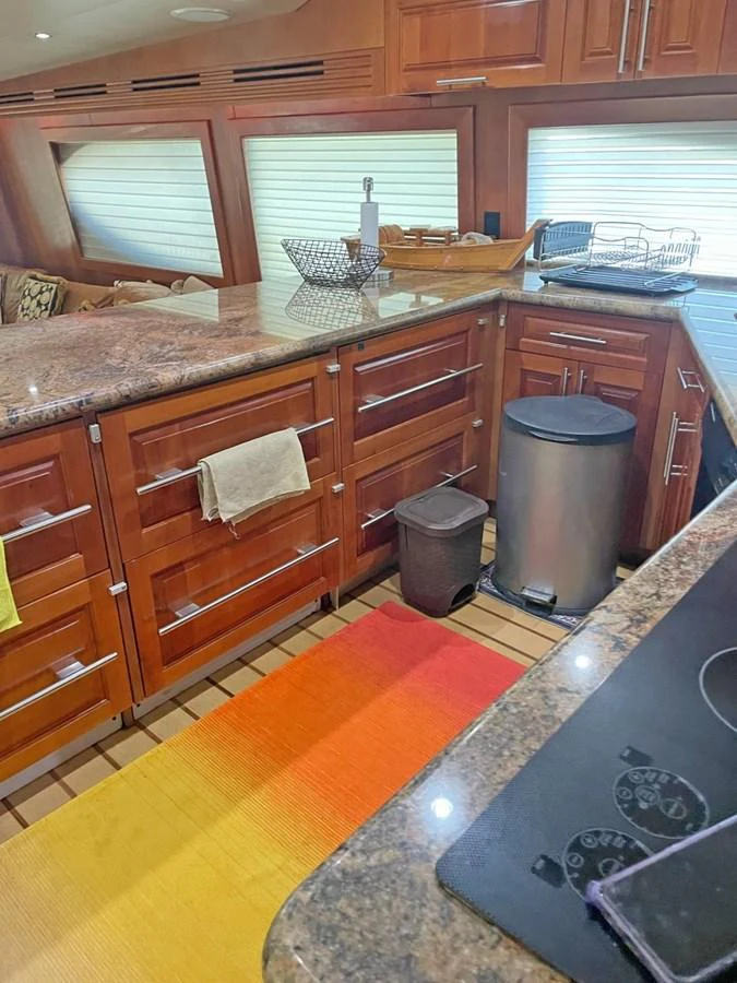 The galley features rich wooden cabinetry, modern appliances, and ample counter space. aboard HATTERAS 68 CONVERTIBLE Yacht for Sale