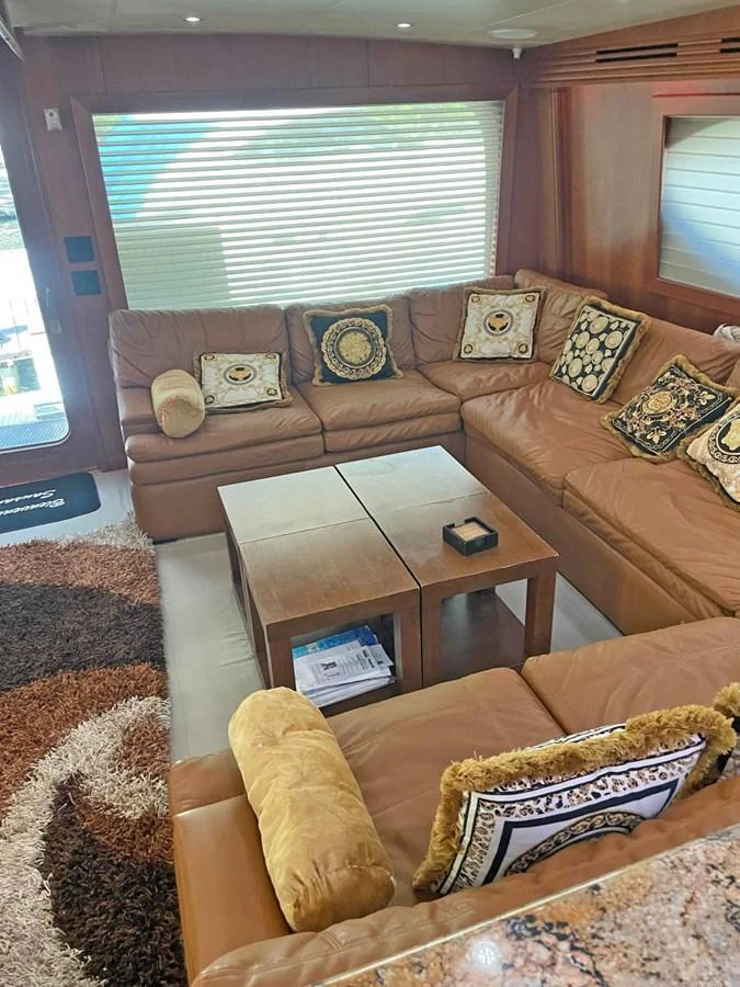 The salon features a cozy seating area with plush leather couches and elegant decor. aboard HATTERAS 68 CONVERTIBLE Yacht for Sale