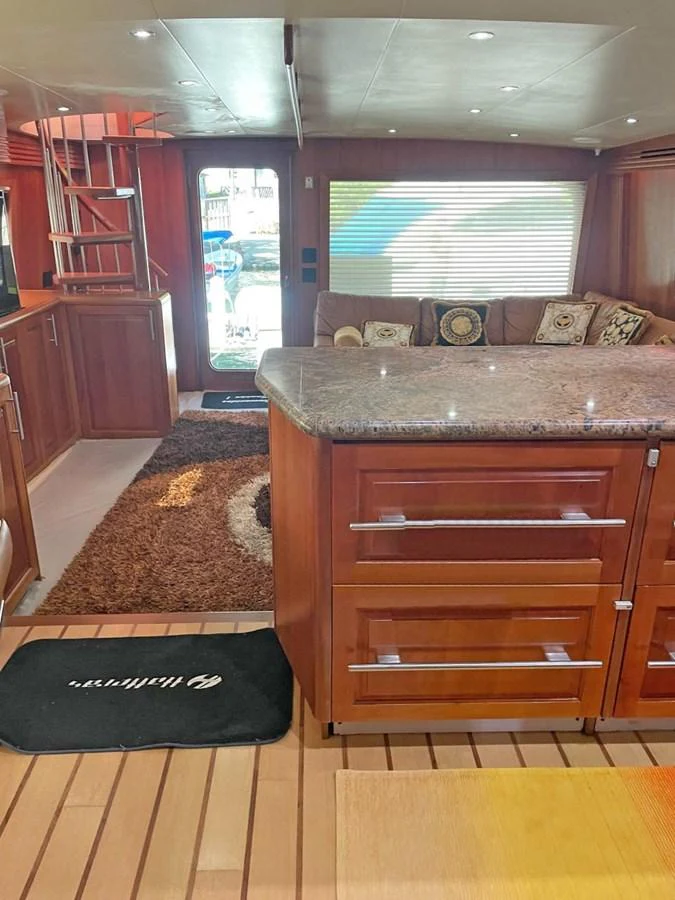 The salon features a cozy seating area with plush cushions and a polished wooden finish. aboard HATTERAS 68 CONVERTIBLE Yacht for Sale