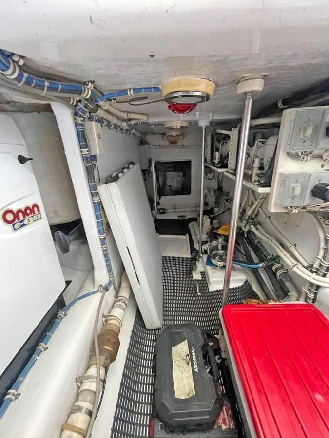 The image showcases a well-organized engine room with various mechanical components and equipment. aboard HATTERAS 68 CONVERTIBLE Yacht for Sale