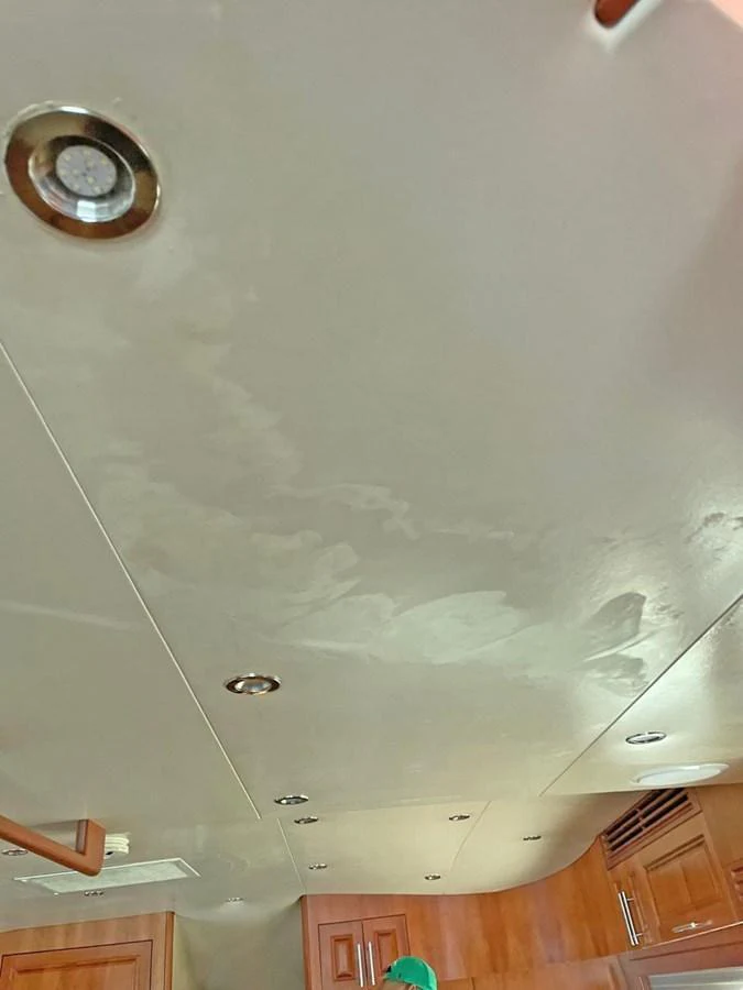 The image shows a section of the yacht's interior ceiling with recessed lighting and wooden cabinetry below. aboard HATTERAS 68 CONVERTIBLE Yacht for Sale