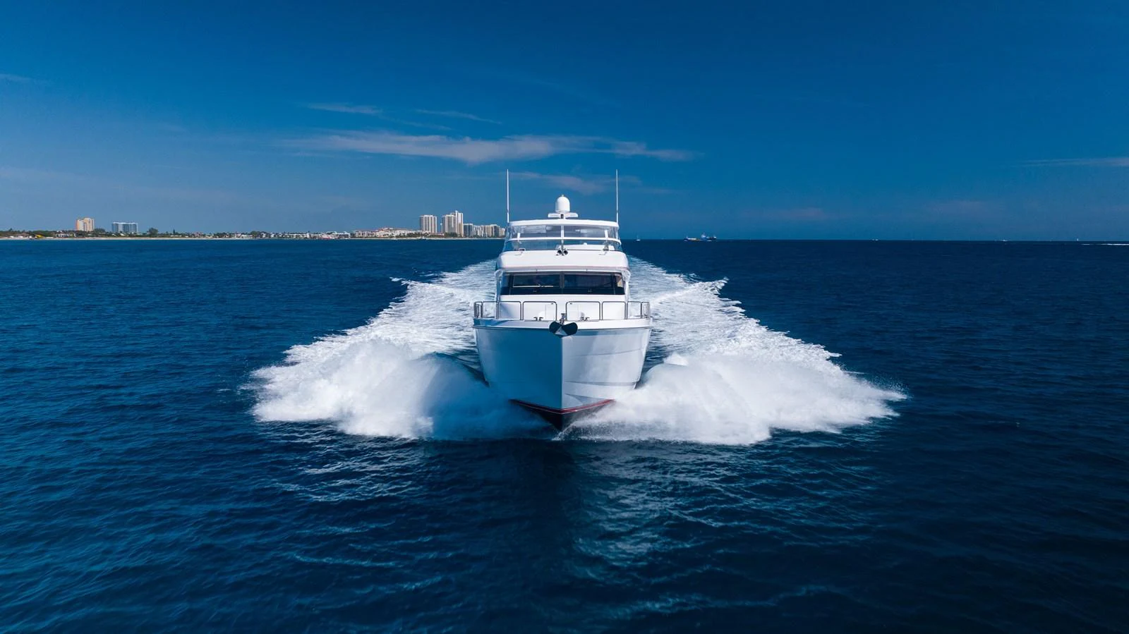 A sleek yacht cuts through the water, showcasing its powerful performance and elegant design. aboard OUTRAGEOUS Yacht for Sale