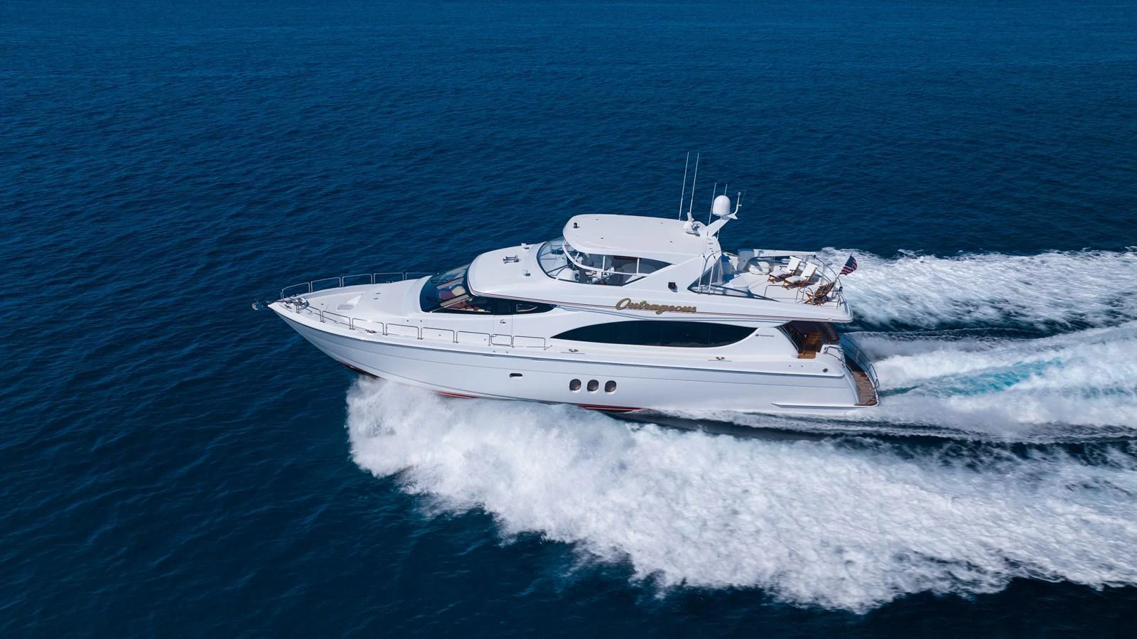 A sleek yacht cruises swiftly over the open water, showcasing its elegant design and powerful performance. aboard OUTRAGEOUS Yacht for Sale
