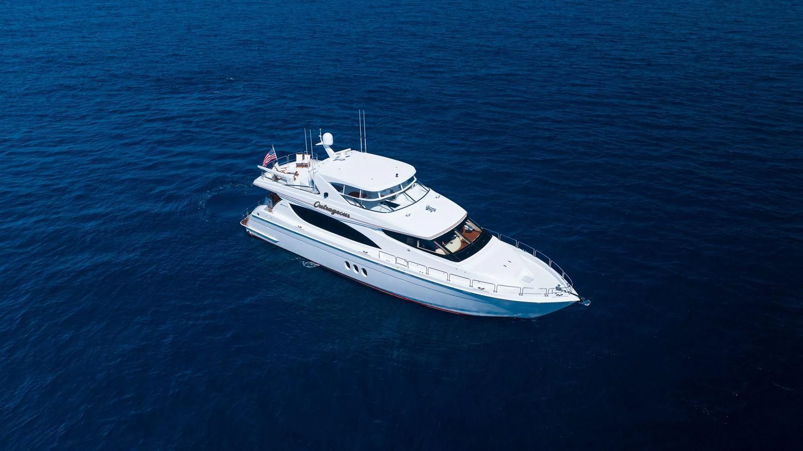 A sleek and elegant yacht cruising on the open sea. aboard OUTRAGEOUS Yacht for Sale