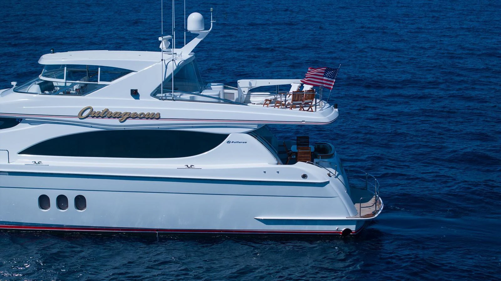 A sleek and elegant yacht cruising on the open sea, showcasing its luxurious design and spacious decks. aboard OUTRAGEOUS Yacht for Sale