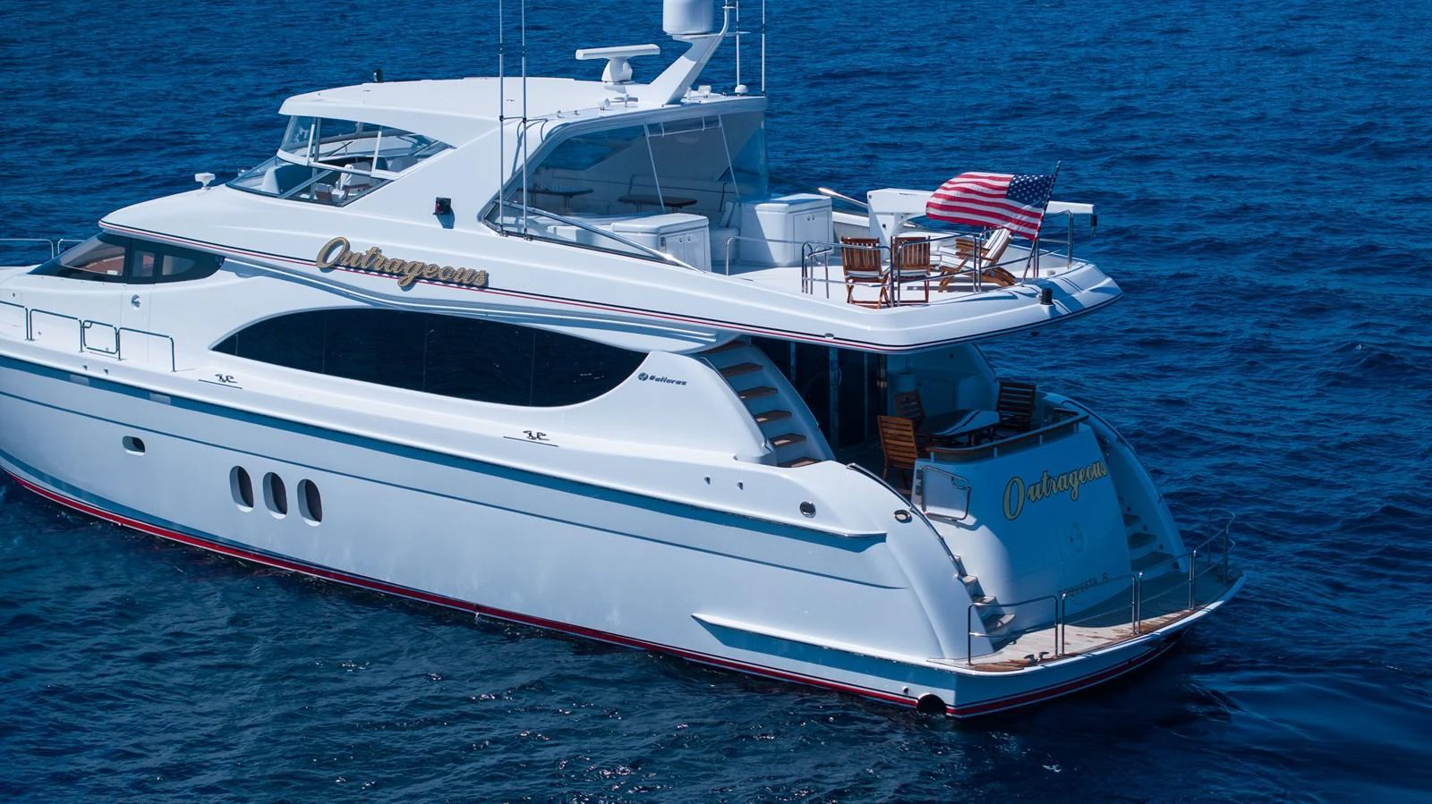 A sleek and elegant yacht cruising on the open sea, showcasing its luxurious design and spacious deck. aboard OUTRAGEOUS Yacht for Sale