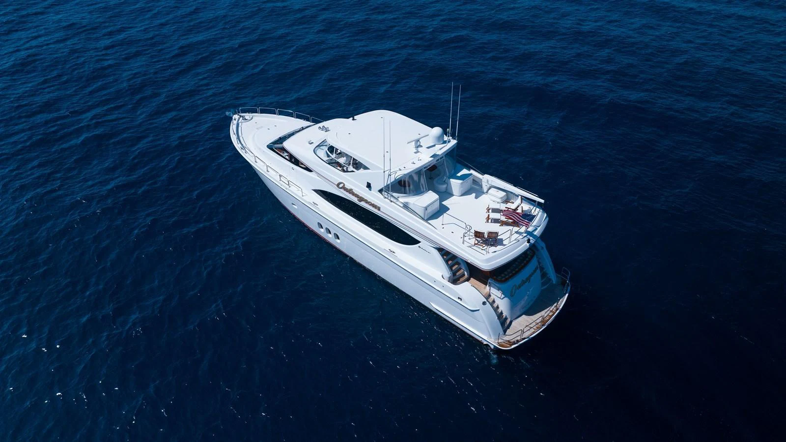 A sleek and elegant yacht cruising on deep blue waters. aboard OUTRAGEOUS Yacht for Sale