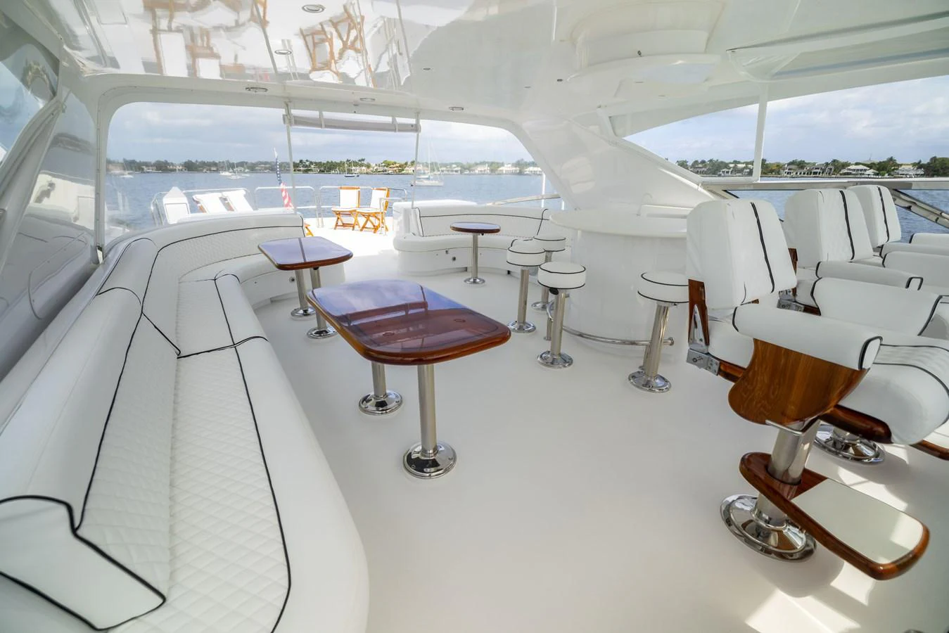 The flybridge features luxurious seating and dining areas with panoramic views. aboard OUTRAGEOUS Yacht for Sale