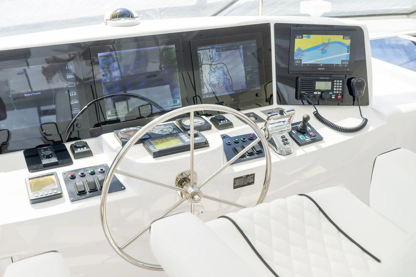 The helm station features advanced navigation equipment and a sleek, modern design. aboard OUTRAGEOUS Yacht for Sale