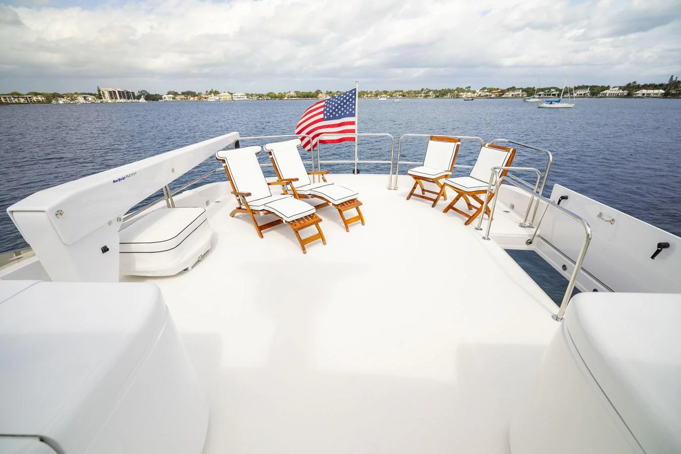 The sundeck offers a relaxing space with lounge chairs and a stunning view of the water. aboard OUTRAGEOUS Yacht for Sale