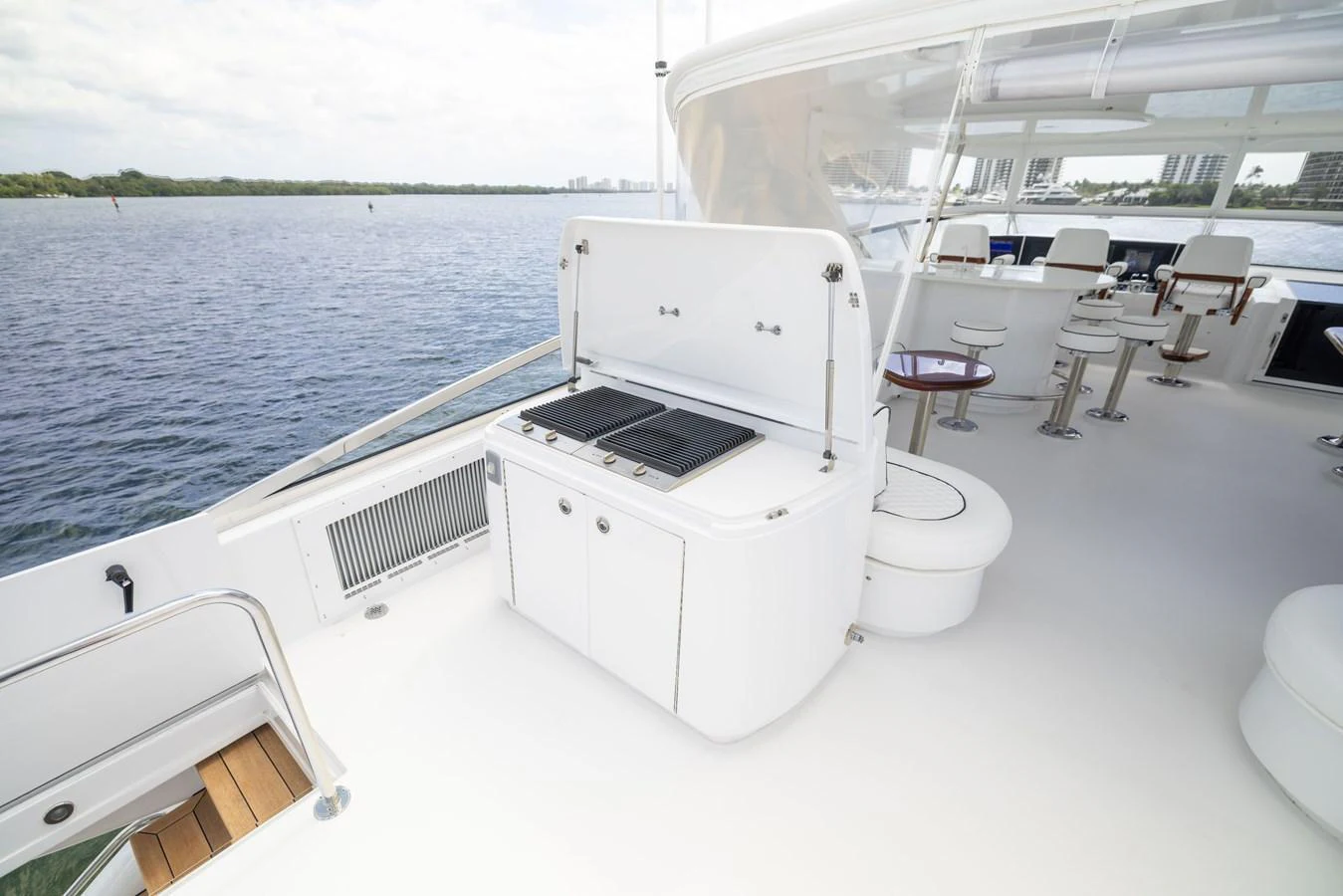 The flybridge features a well-equipped outdoor kitchen with a grill and ample seating, perfect for entertaining. aboard OUTRAGEOUS Yacht for Sale