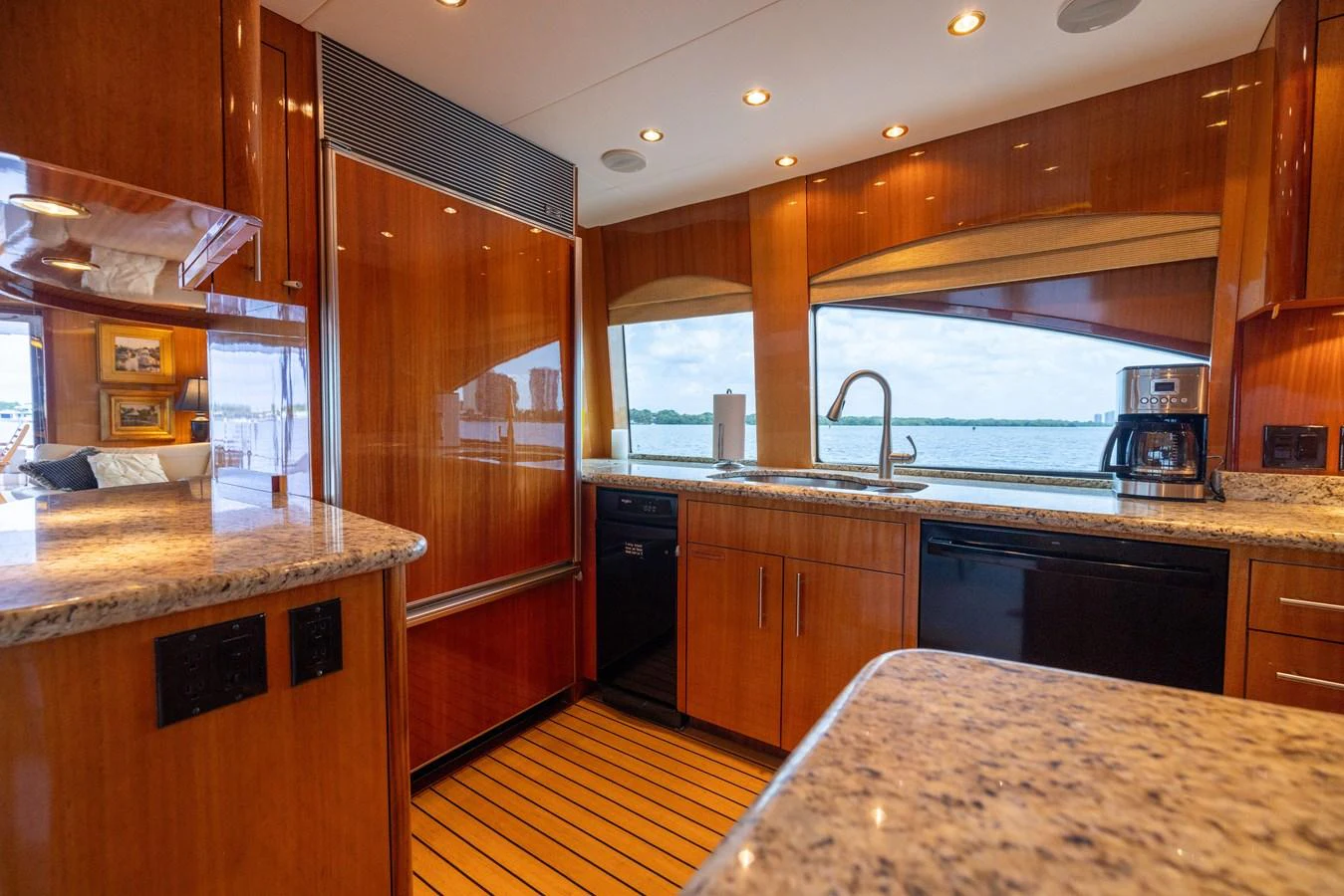 The yacht's galley features sleek wooden cabinetry, granite countertops, and modern appliances, offering a luxurious and functional space for meal preparation. aboard OUTRAGEOUS Yacht for Sale
