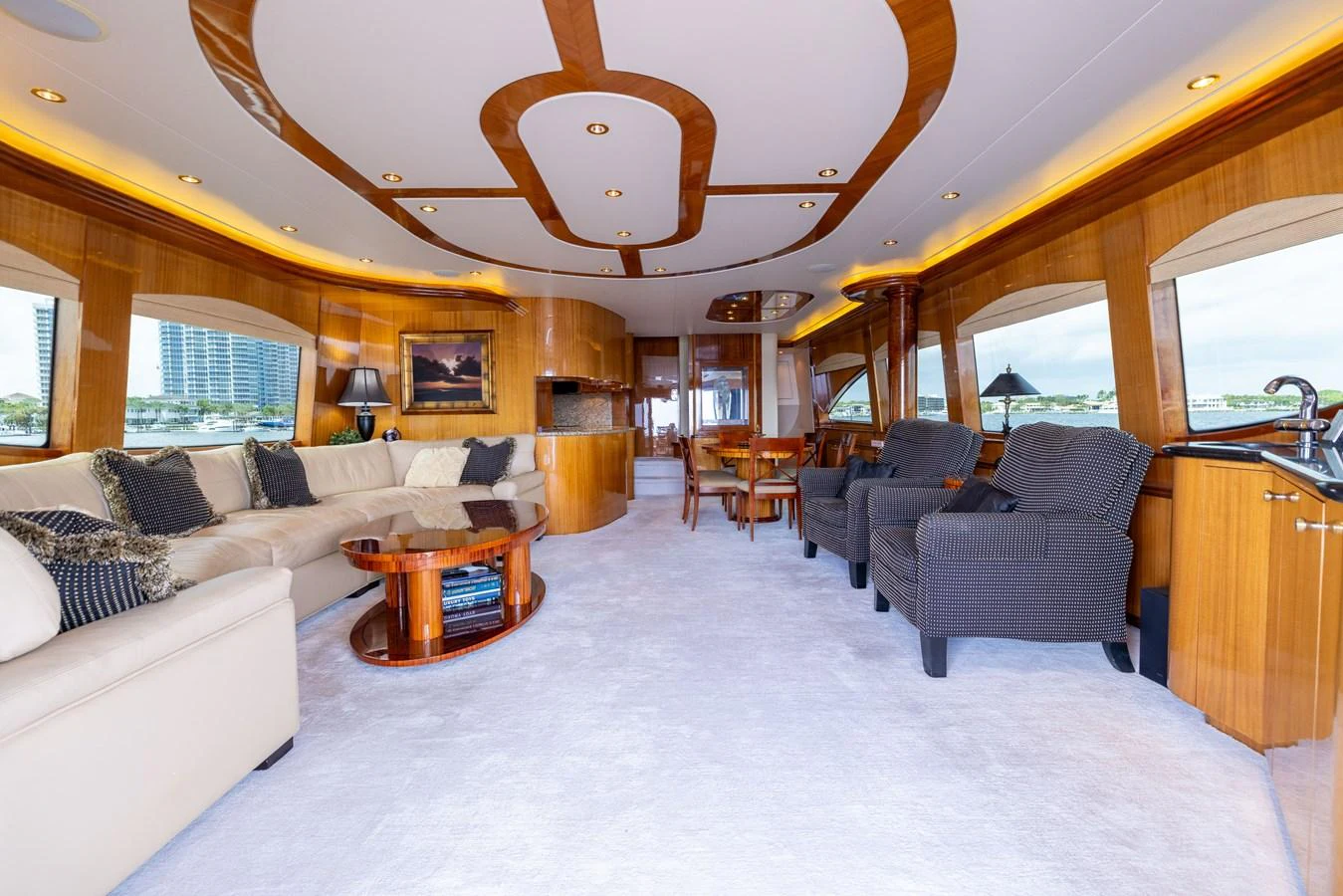 The yacht's salon features luxurious seating, elegant wood accents, and large windows for natural light. aboard OUTRAGEOUS Yacht for Sale