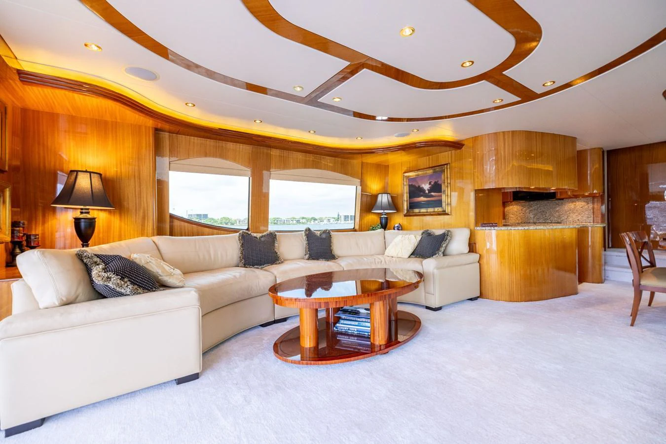 The salon features a spacious and elegant seating area with luxurious furnishings and warm lighting. aboard OUTRAGEOUS Yacht for Sale