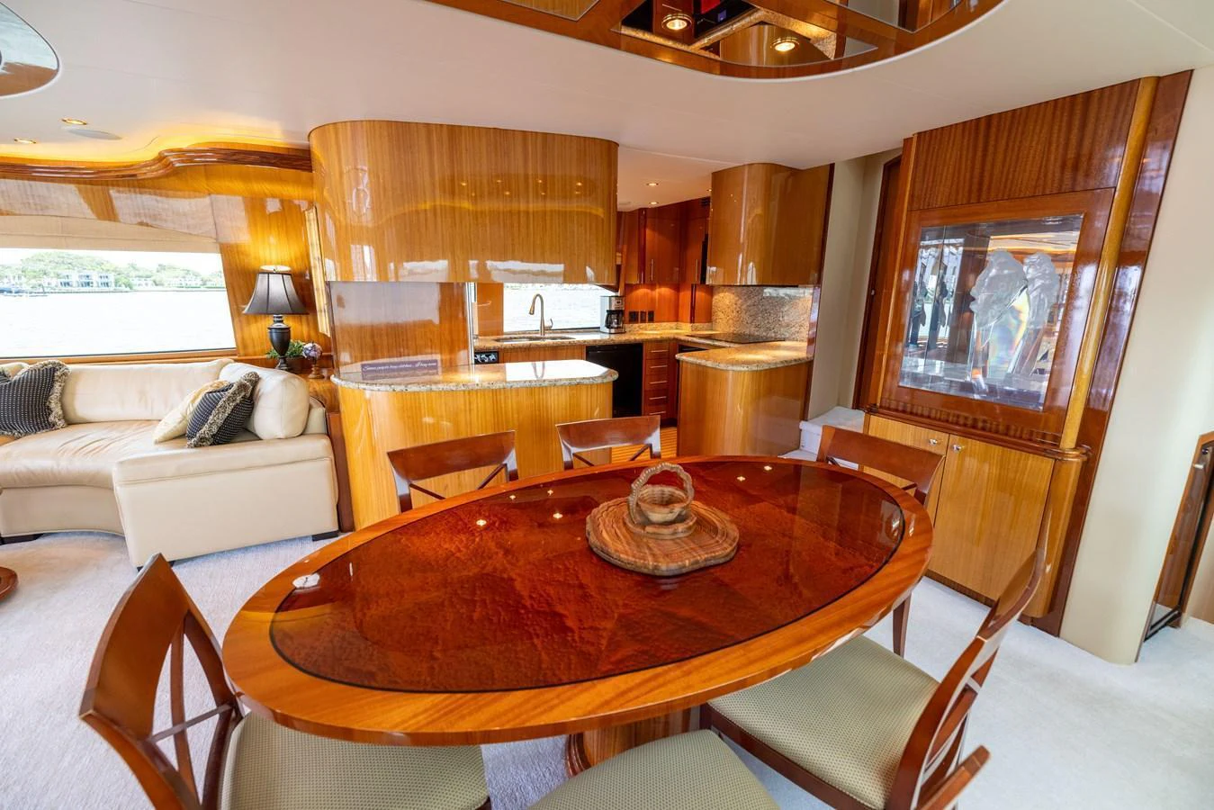 The yacht's dining area features a polished wooden table and elegant seating, complemented by a well-equipped galley. aboard OUTRAGEOUS Yacht for Sale
